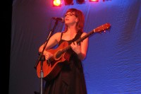 Lisa Loeb singing at a music convention.